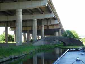The traditional Blakeley Hall Bridge under the elephantine legs of the M5
